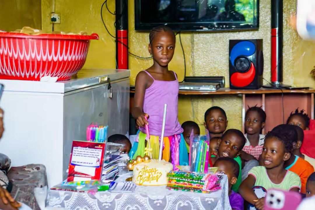 Children gathered around a birthday cake